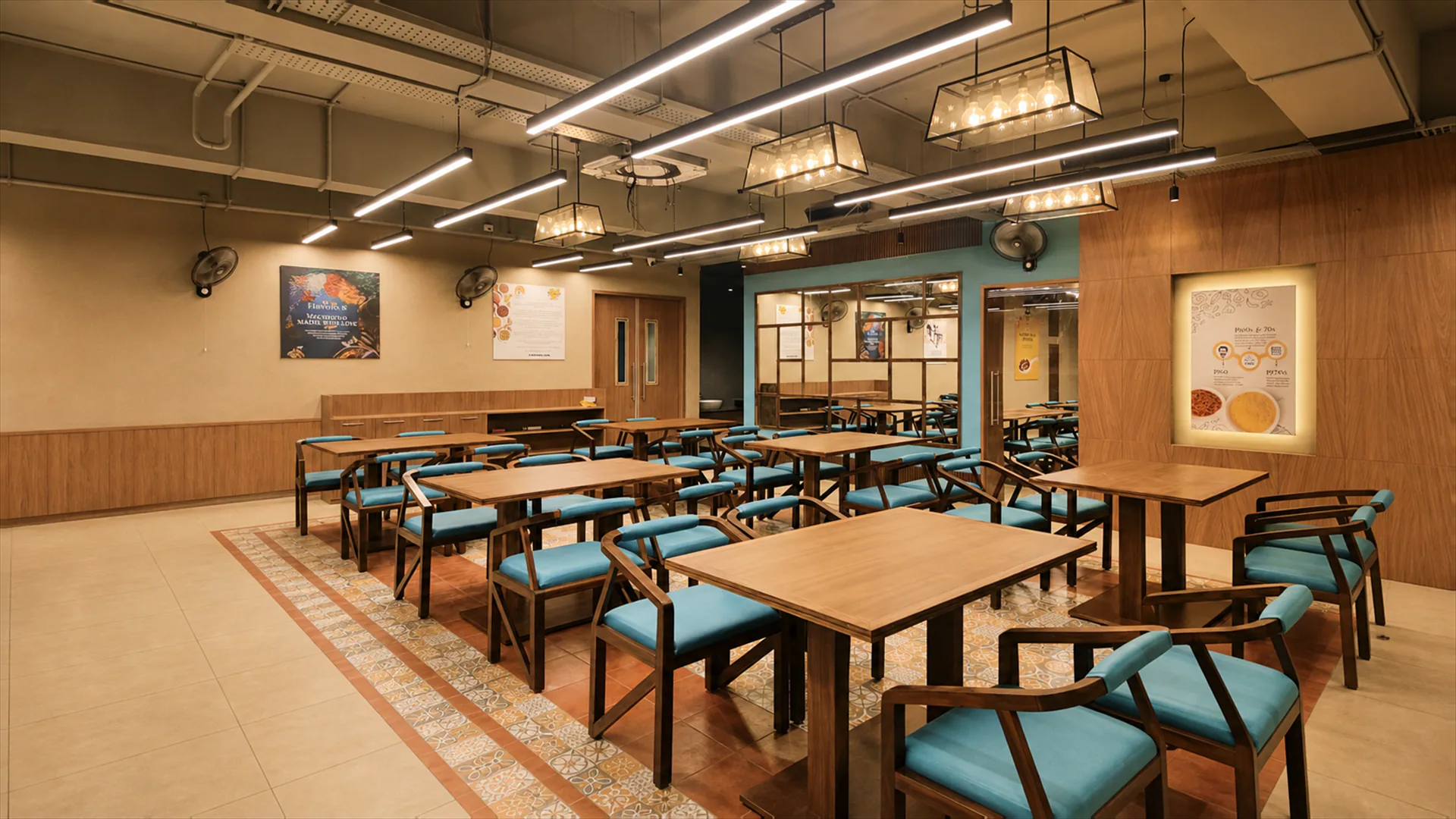 Wide dining room with timber tables, turquoise chairs and illuminated wall graphics.