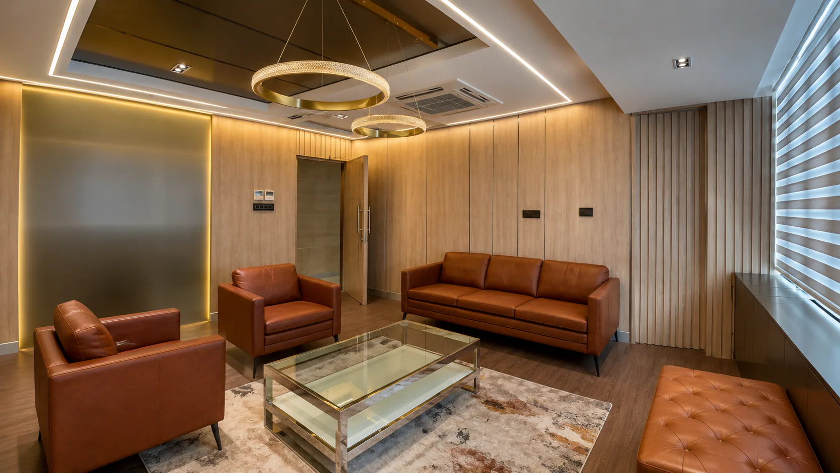 Reverse view of the hospital lounge with sofas around a glass table.