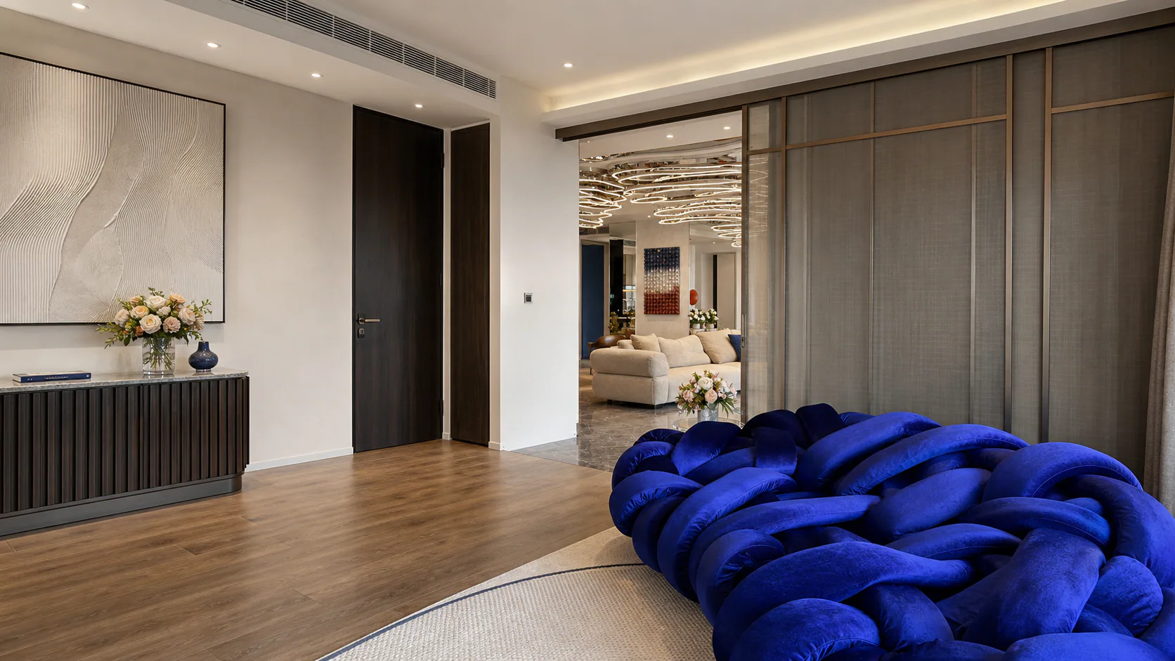 Bedroom with a deep-blue upholstered bed and a wide doorway to the living area.