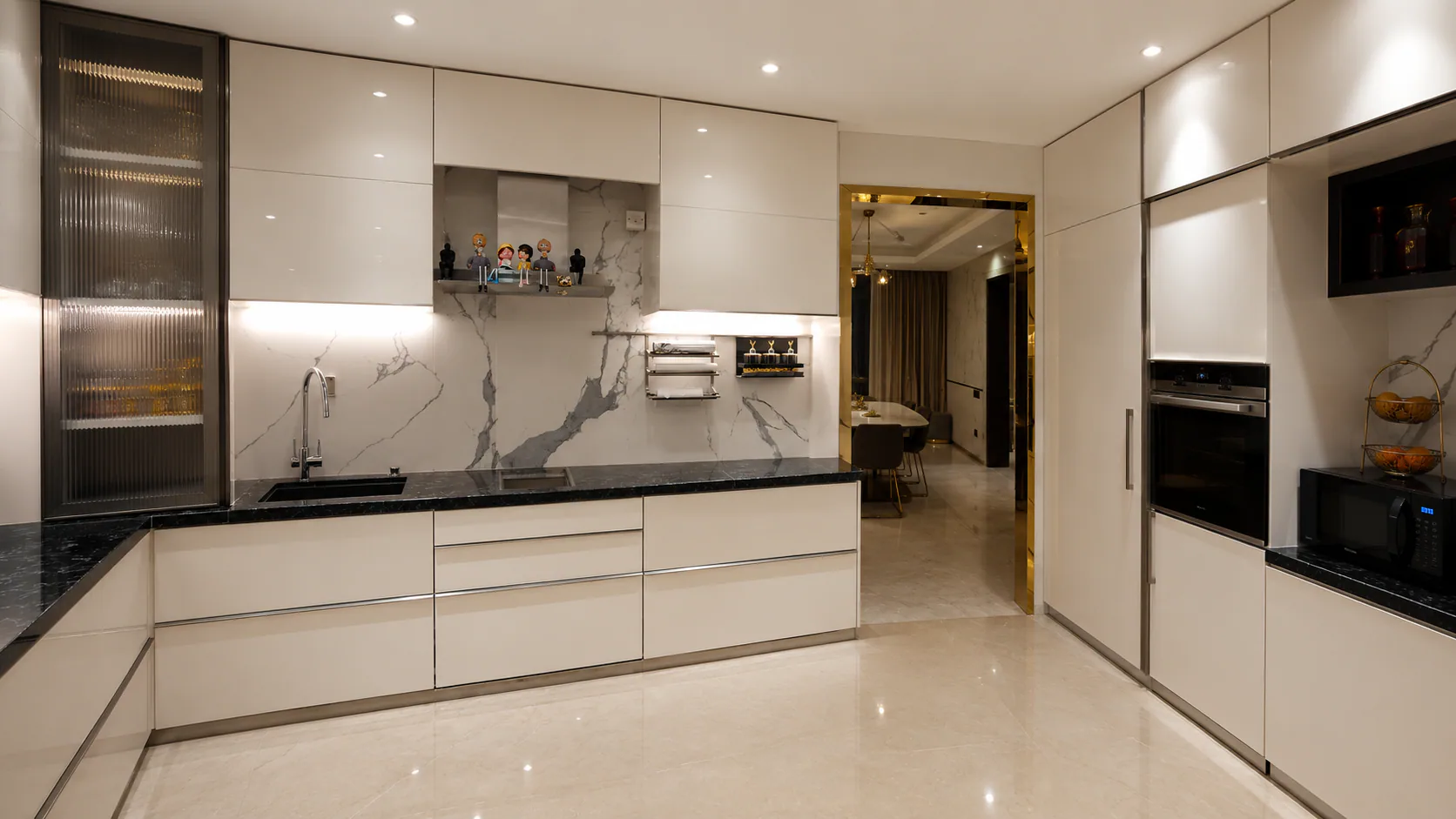 White kitchen with a central worktop, tall cabinets and integrated appliances.